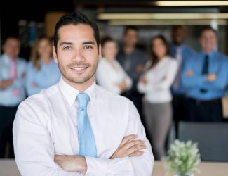 Successful man leading a business group Portrait of a confident successful man leading a business group and looking at the camera